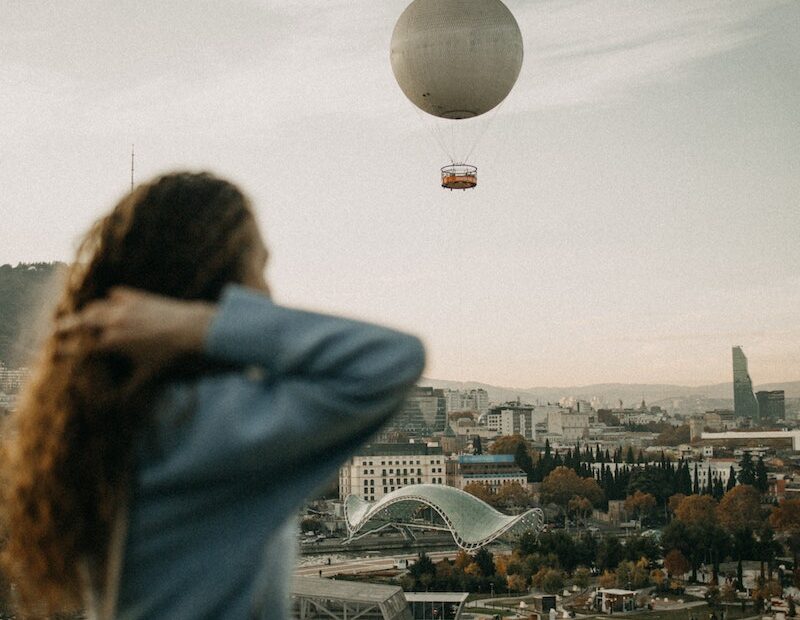 Woman Sitting on the Rooftop and Looking at the Cityscape of Tbilisi, Georgia