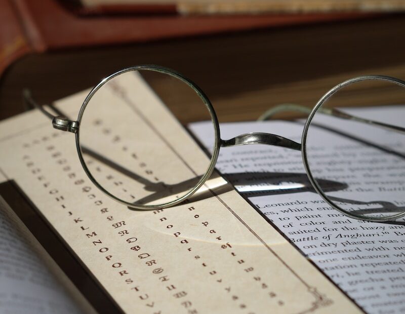 silver framed eyeglasses on white paper